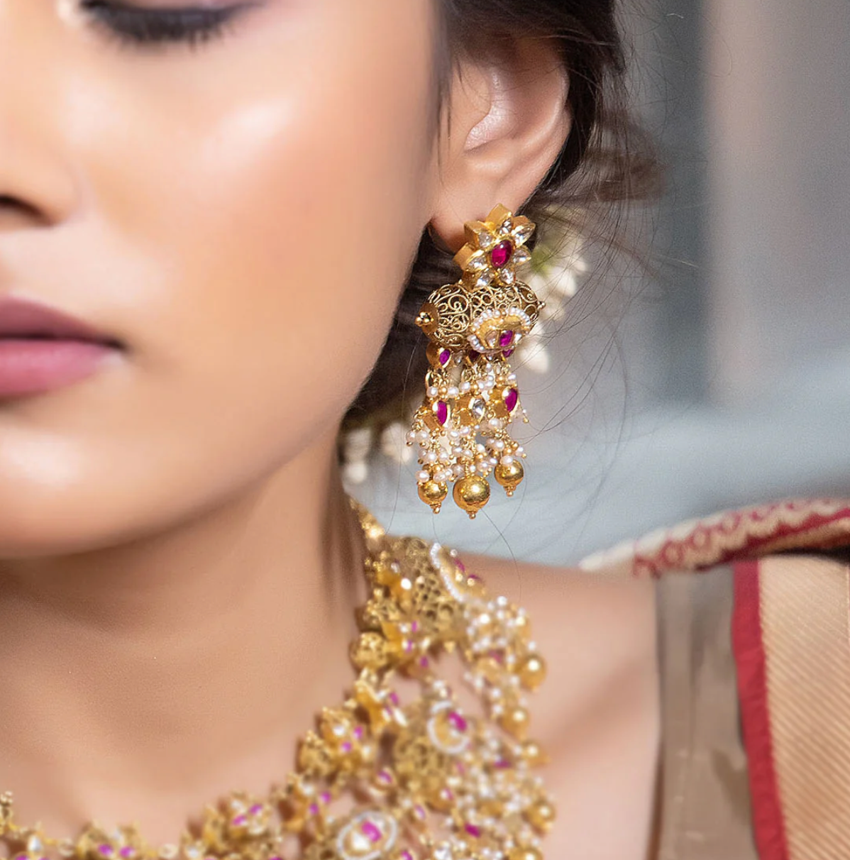 Kaliganthi Earrings handcrafted in gold with filigree detailing, a tawiz-inspired pendant, polki (uncut) diamonds, ruby accents, pearls, and traditional Indian craftsmanship.
