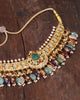 Amer gold Navratna choker necklace featuring polki diamonds, ruby and emerald accents, a chaand motif, hessonite, citrine and emerald gemstone drops, and layered cultured pearl strands.