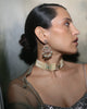Woman wearing Nehir gold earrings featuring diamonds, emeralds, and cultured pearls