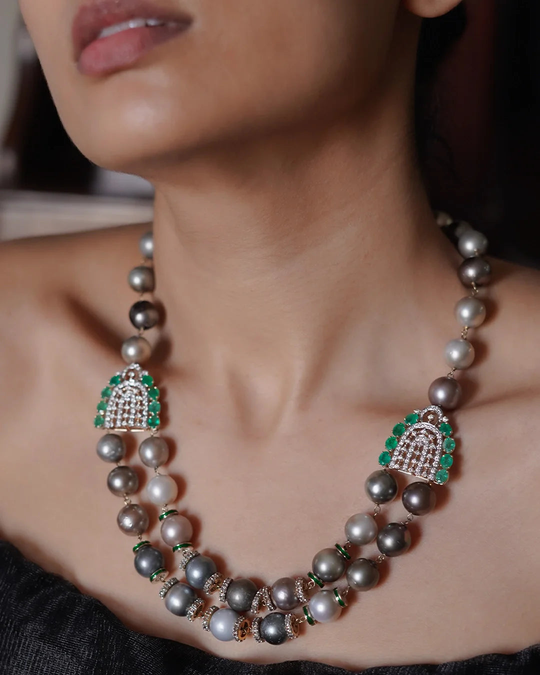 Sanea Necklace featuring multiple strands of cultured pearls with green enamel and rose-cut diamond disks, finished with diamond and emerald clasps