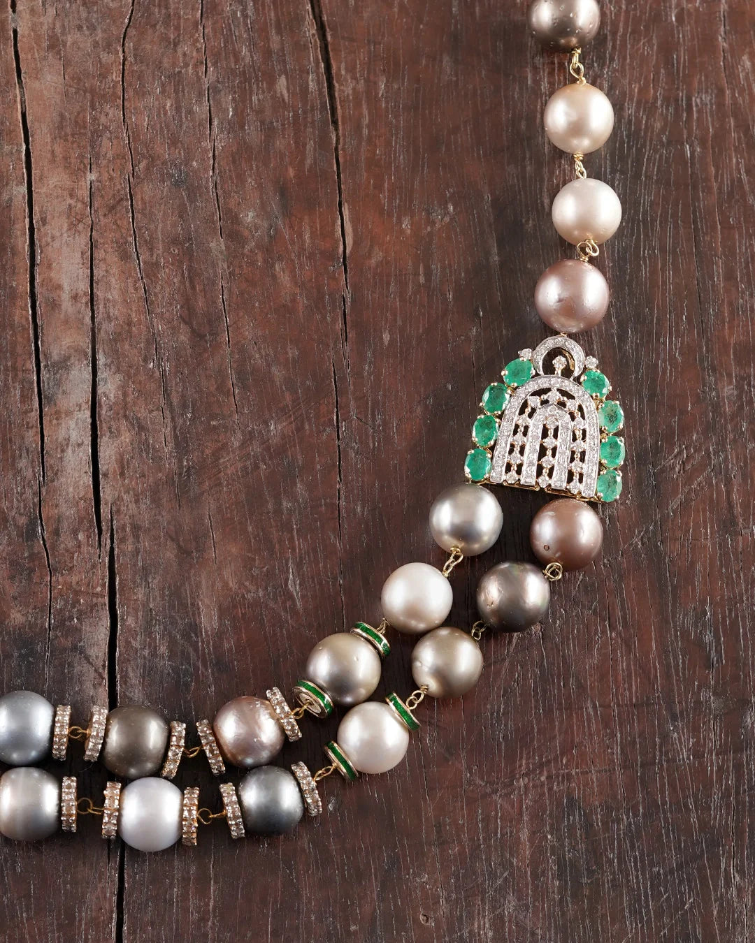 Sanea Necklace featuring multiple strands of cultured pearls with green enamel and rose-cut diamond disks, finished with diamond and emerald clasps