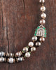 Sanea Necklace featuring multiple strands of cultured pearls with green enamel and rose-cut diamond disks, finished with diamond and emerald clasps