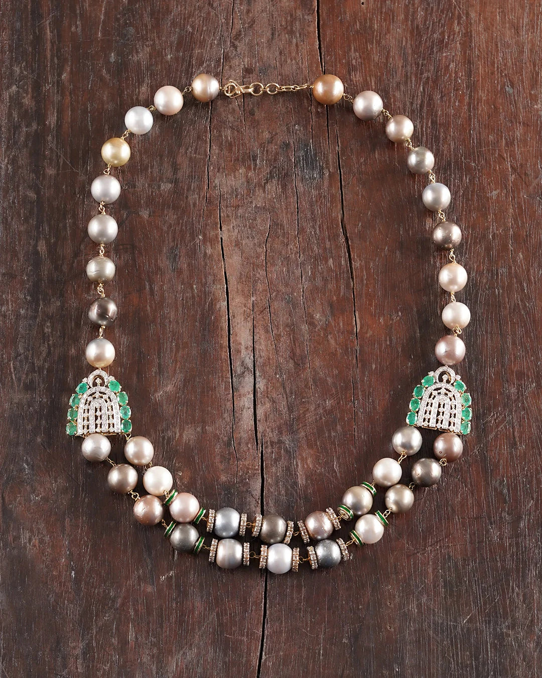 Sanea Necklace featuring multiple strands of cultured pearls with green enamel and rose-cut diamond disks, finished with diamond and emerald clasps