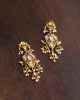 Gold earrings with uncut polki diamond clusters, oval emerald cabochons, and pearl-pastel gemstone danglers for women