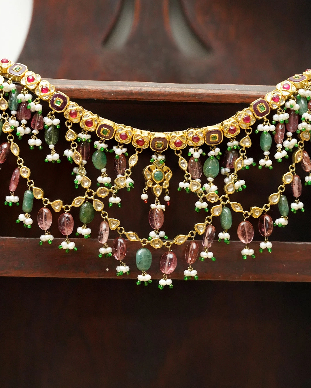 Gold Kaivi Necklace with kundan-set uncut diamonds, rubies, emeralds, pearls, green enamel accents, and cascading seed pearls and tourmaline beads for women.