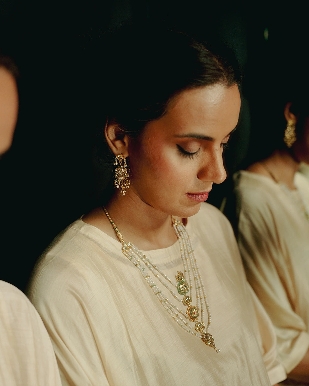 Layered panchlada necklace with pearls, emerald beads, uncut diamonds, and vibrant gemstones set in gold for women.